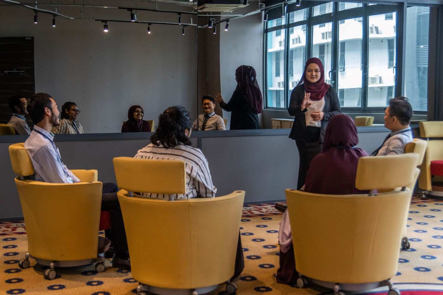 APU students with their lecturers in a psychology observation suite with a one-way mirror.